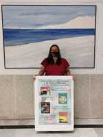 Clara Pérles junto al cartel de presentación